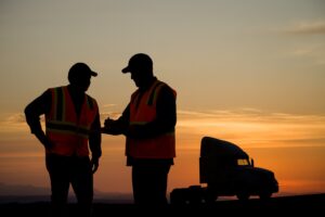 two drivers in the dawn, truck on the background